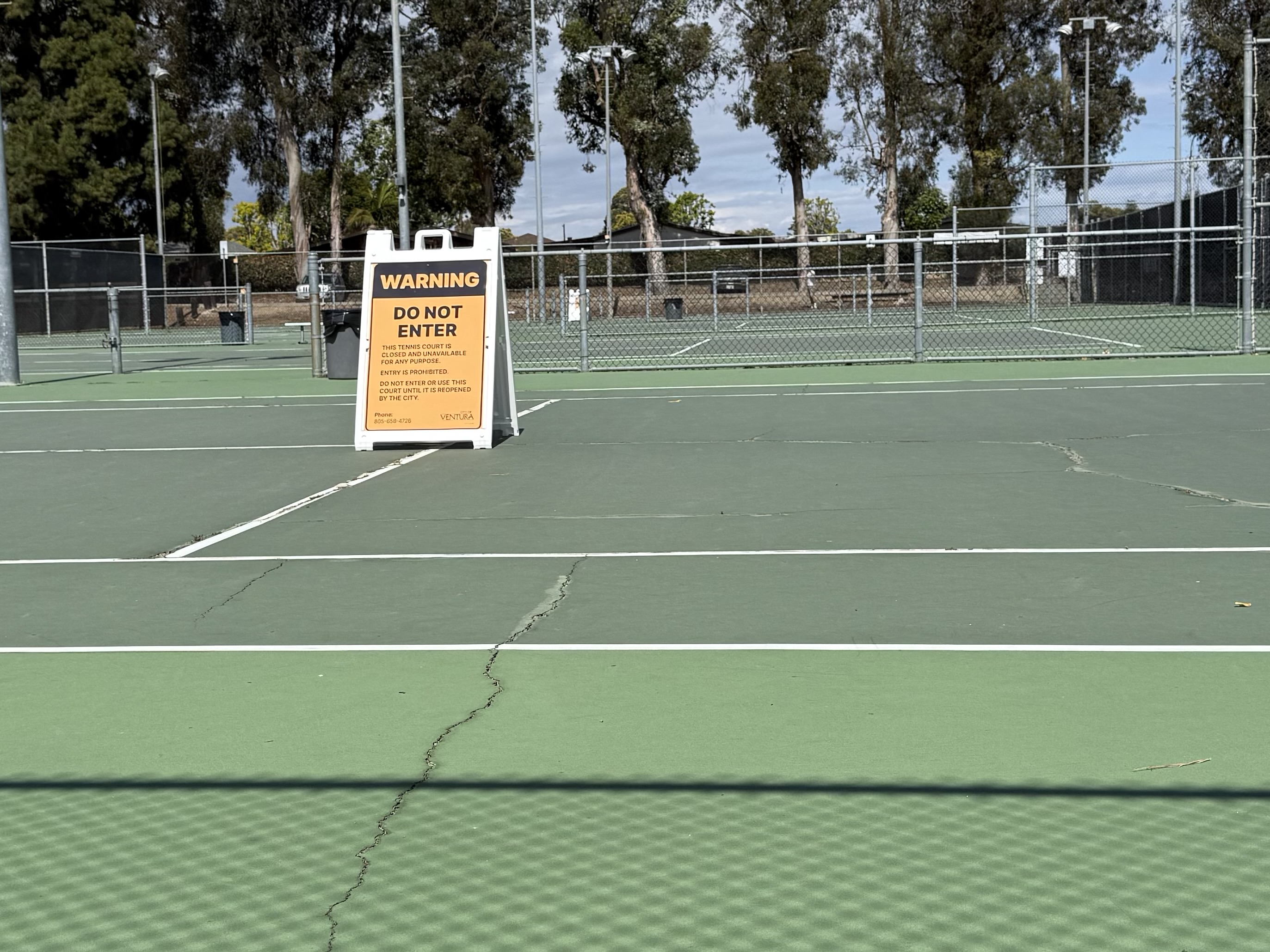 Camino Real Park tennis courts — City of Ventura WARNING DO NOT ENTER sign on cracked, closed courts